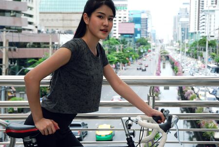Beautiful Sport woman ride bicycle on walking street.の写真素材