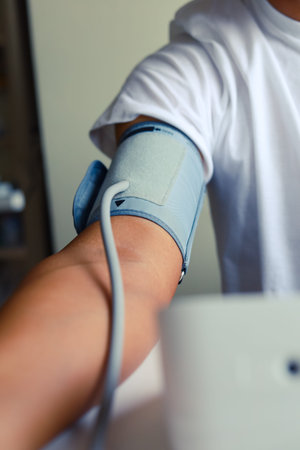 Close-up man measure pressure by yourself in room.