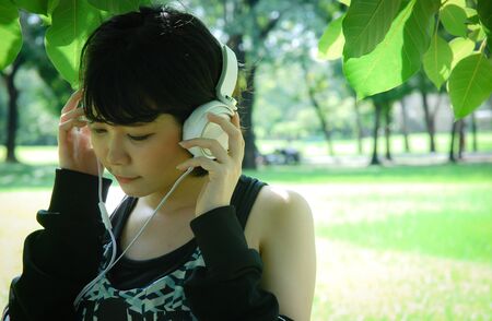 Beautiful sport woman smile portrait and listening music in public park.の写真素材