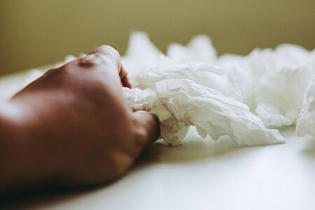 Close-up hand holding white paper tissue background.の写真素材