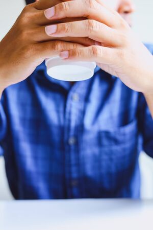 Close-up business man hand holding coffee cup and thinking creative work in home office.の写真素材