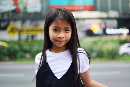 Beautiful Asian kid girl smile portrait and walking traveling on walking street in the city.の写真素材