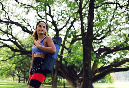 Beautiful African American woman sport smile portrait and walking relaxation in the garden.の写真素材