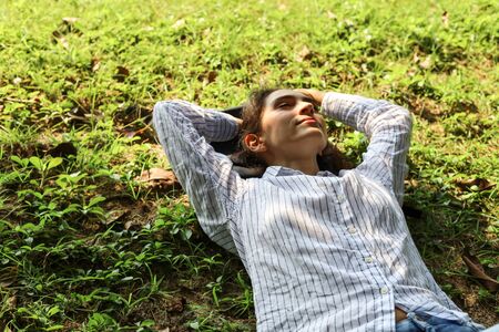 Beautiful woman sleeping relaxation on green grass in the garden.の写真素材