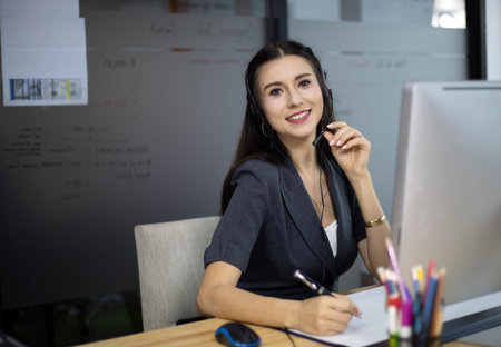 Beautiful reception call center woman speaking and talking with customer on phone line.の写真素材