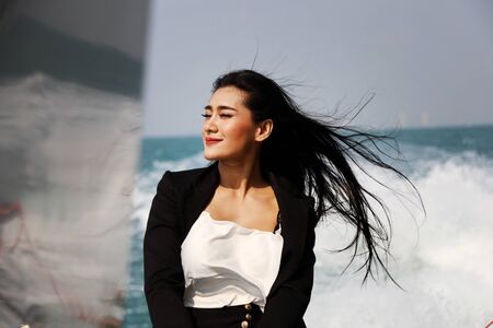 Beautiful Asia woman smile portrait traveling on speed boat in summer for relaxation at Thailand.の写真素材