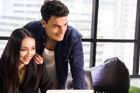 Happiness business young couple lover working at desk in the office.の写真素材