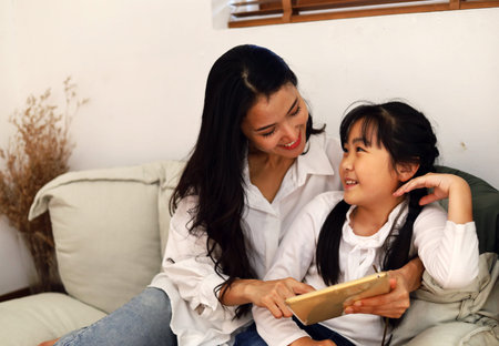 Happiness young woman mother smile stay at home with girl kid and working business from home.の写真素材