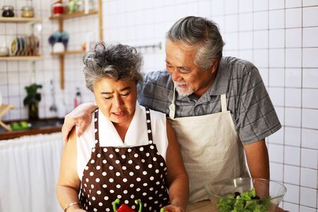 Happiness senior elderly couple having fun in kitchen with healthy food for working from home. COVID-19の写真素材