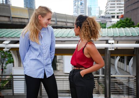 Two young business woman smile talking and relaxation in free time at walking street.の写真素材