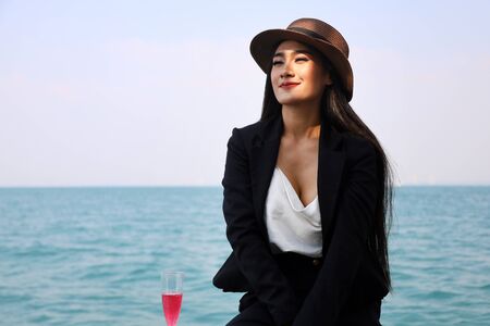 Beautiful asia woman traveling for relaxation and drinking wine on speed boat at Thailand.の写真素材