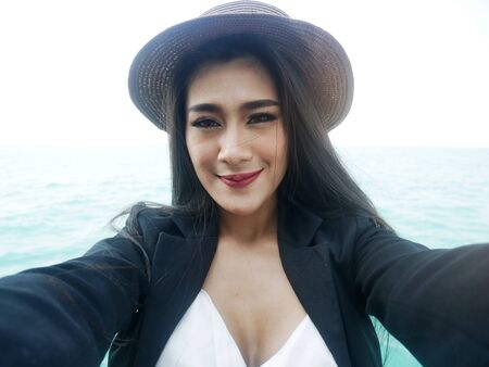 Beautiful Asia woman selfie portrait on beach and traveling in holiday weekend.の写真素材