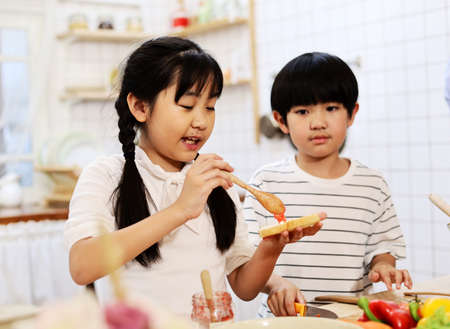 Asia two children are cooking food in the kitchen on a holiday in home.の写真素材