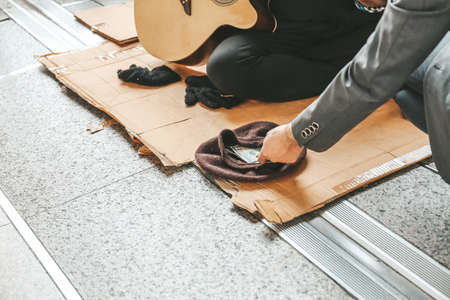 Senoir homeless man sitting and playing acoustic guitar.の写真素材