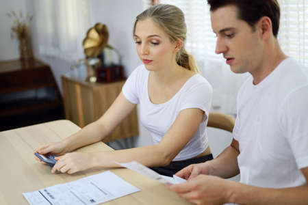 Unhappy young couple feeling worried about the cost for credit card bills at home.の写真素材