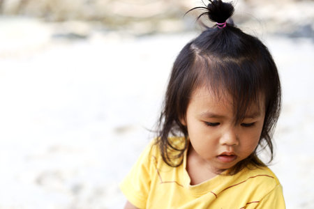 Beautiful Asia kids girl playing sand and sea in holiday weekend.の写真素材