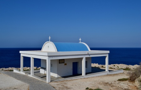 Blue and white church with sea in the backgroundの写真素材