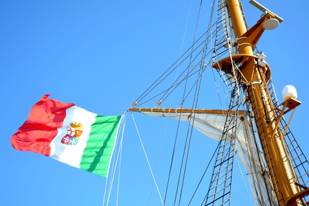 Details of outdoor exterior of an Italian ship with flag and blue skyの写真素材