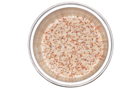 Uncooked Brown rice grains in rice cooker top view backgroundの写真素材