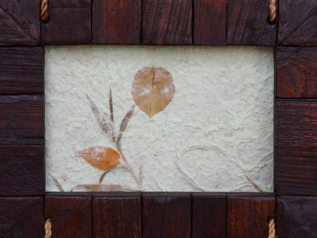 A frame made from pieces of wood and mulberry paper with brown leafの写真素材