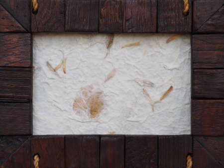 A frame made from pieces of wood and mulberry paper with brown leafの写真素材