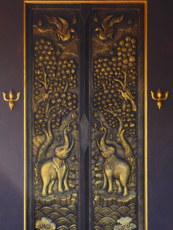 Tracery golden doors in a temple of Thailandの写真素材