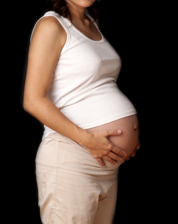 Pregnant woman with hands over tummy.の写真素材
