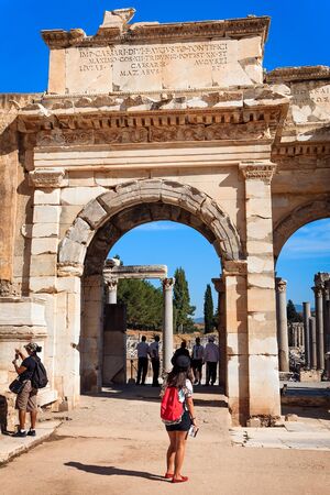 EPHESUS, TURKEY - SEPTEMBER 30, 2014: Woman Tourist with a guide book admires the Gate of Augustus in Efesのeditorial素材