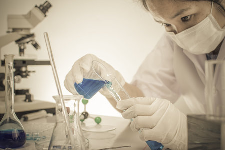 Scientists are experimenting with chemicals. A scientific beaker vitro camera microscope can be used...