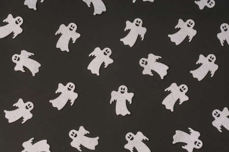 Pattern made of smiling ghost figures on a black backgorund. Halloween concept.の写真素材