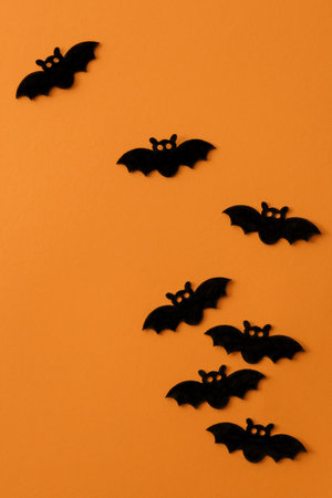 Group of bats against orange background. Flat spooky Halloween composition.の写真素材