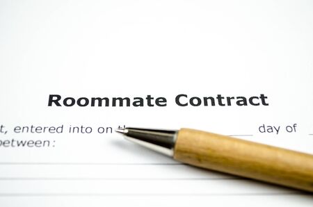 Roommate contract with wooden penの写真素材