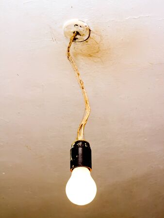 old dirty light bulb without canopyの写真素材