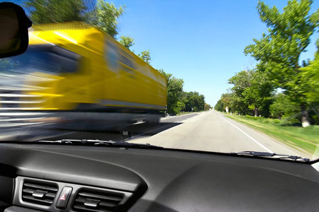 Blurred on the speed of the movement of trucks on the road from the window of an oncoming carの写真素材