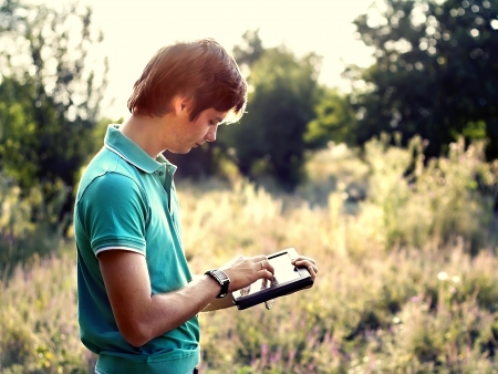 young guy with a tablet outdoorsの写真素材