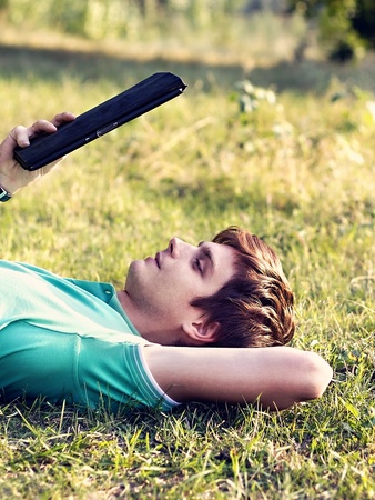 young guy with a tablet outdoorsの写真素材
