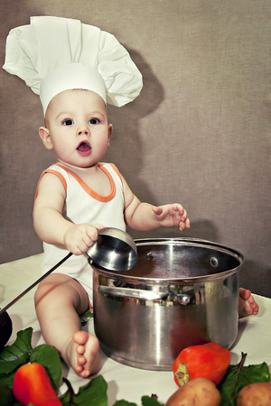little baby in a chef's hat and ladle in handの写真素材