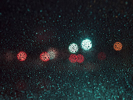 raindrops on the glass on blur background of colored spotsの写真素材