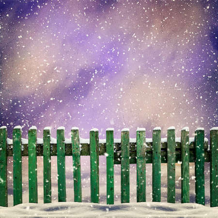 snowy old green wooden fence and falling snowの写真素材