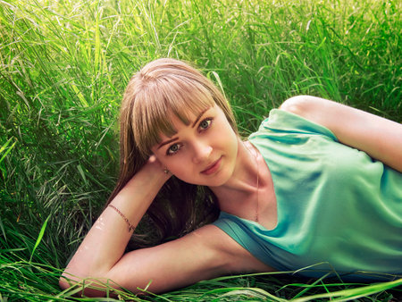 Young beautiful girl lying on the grass