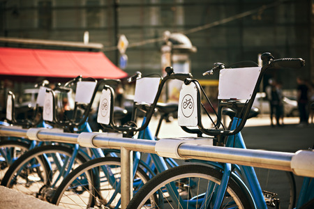standing in a number of bicycles for hire on a city streetの写真素材