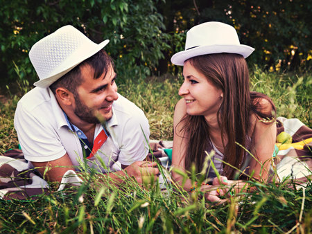 happy young couple relaxing in the park on the grassの写真素材