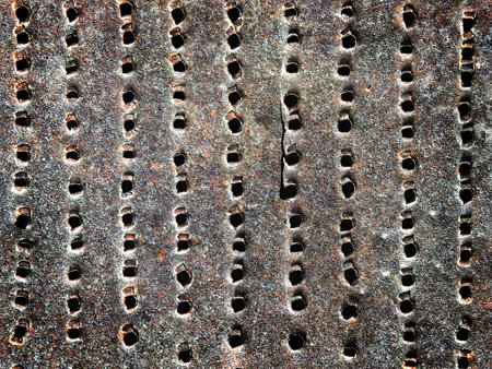 old rusty iron sheet with holes as a background