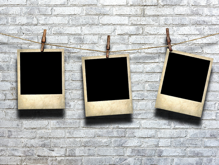 photo on rope with clothespins on a background of a brick wallの写真素材