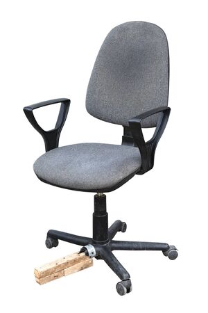 Old office chair with a piece of wood instead of a broken leg Isolated on a white backgroundの写真素材