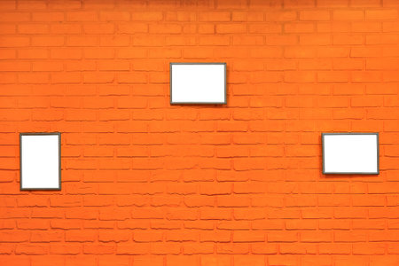 orange brick wall with gray picture frames as backgroundの写真素材