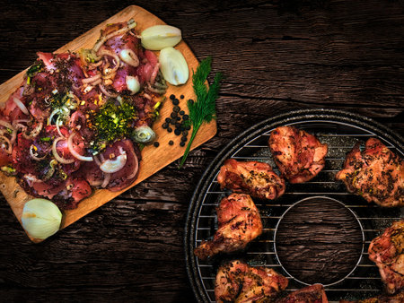barbecue grill with meat and spices on a wooden tableの写真素材