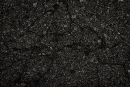old dark asphalt texture with cracks as a background. Created without the use of artificial intelligenceの写真素材