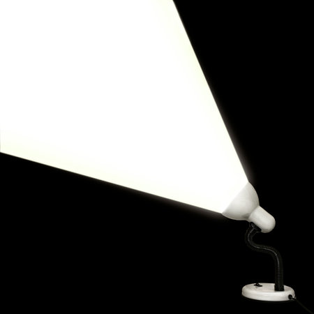Table lamp shines white light on a black backgroundの写真素材