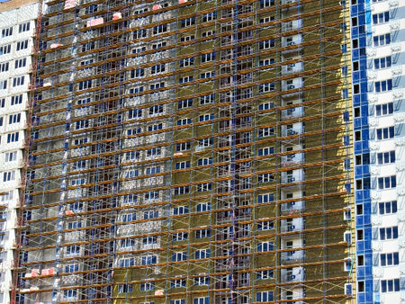 multi-storey residential building in scaffolding for finishing the facadeの写真素材